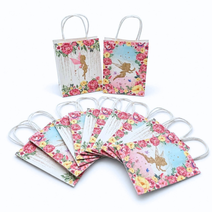 a set of 12 gift bags with white twisted paper handles, decorated with colorful floral borders and gold fairy illustrations, shown on a plain white background.