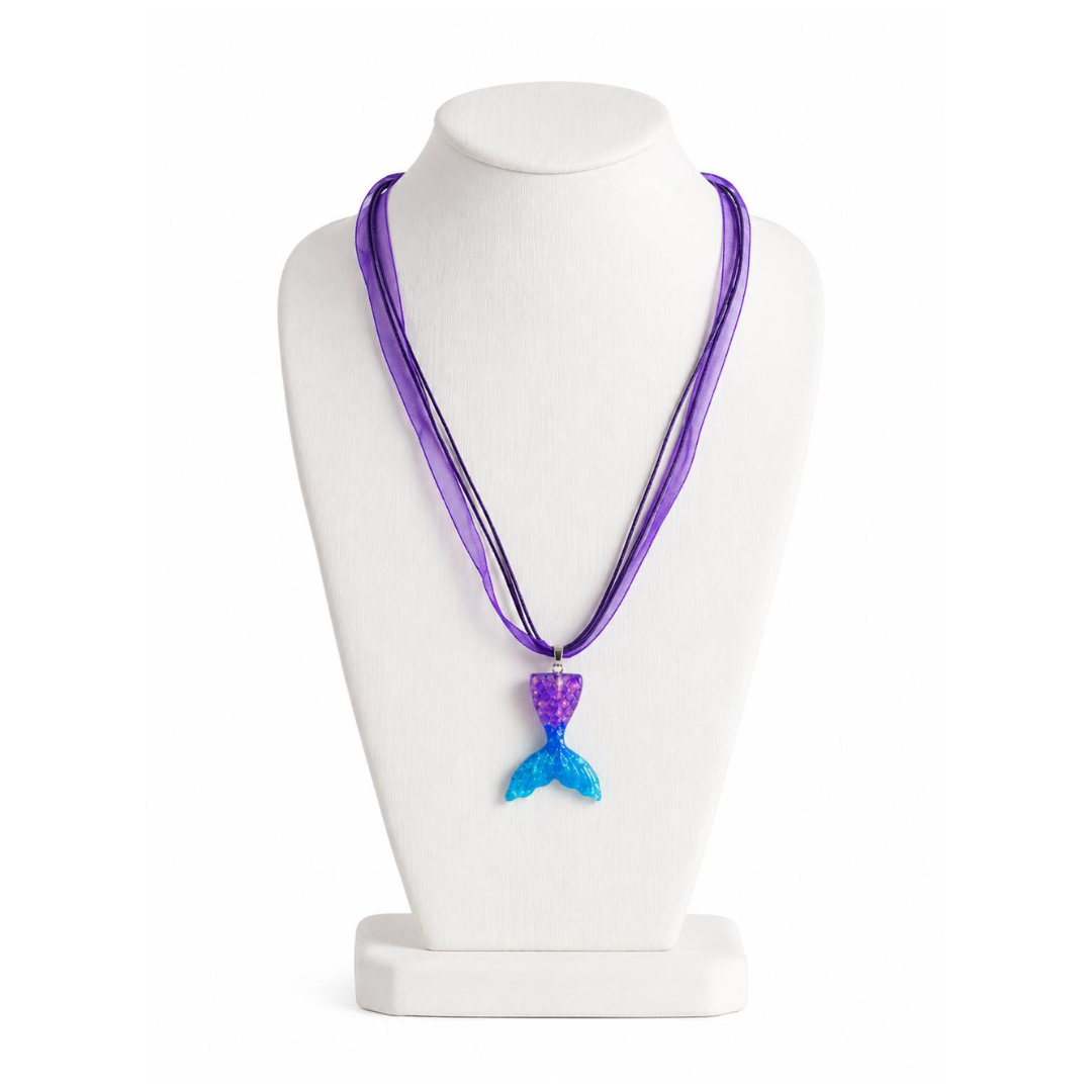 Purple necklace with a blue mermaid tail pendant on a white mannequin bust.