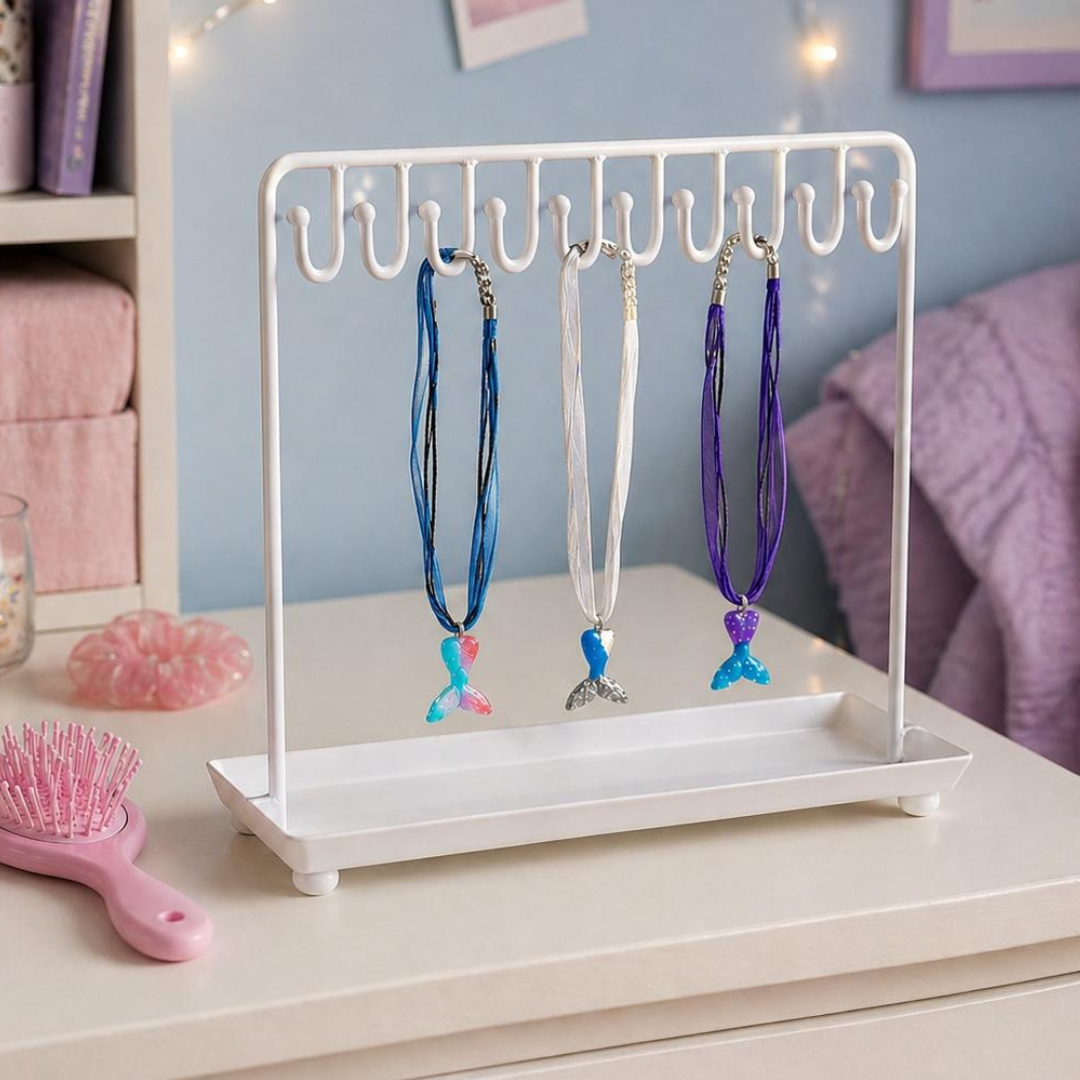 Necklace stand with colorful necklaces on a white surface, with a pink hairbrush and decorative items in the background.