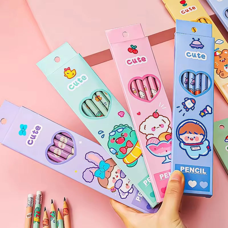A hand holding 4 colored pencil boxes 