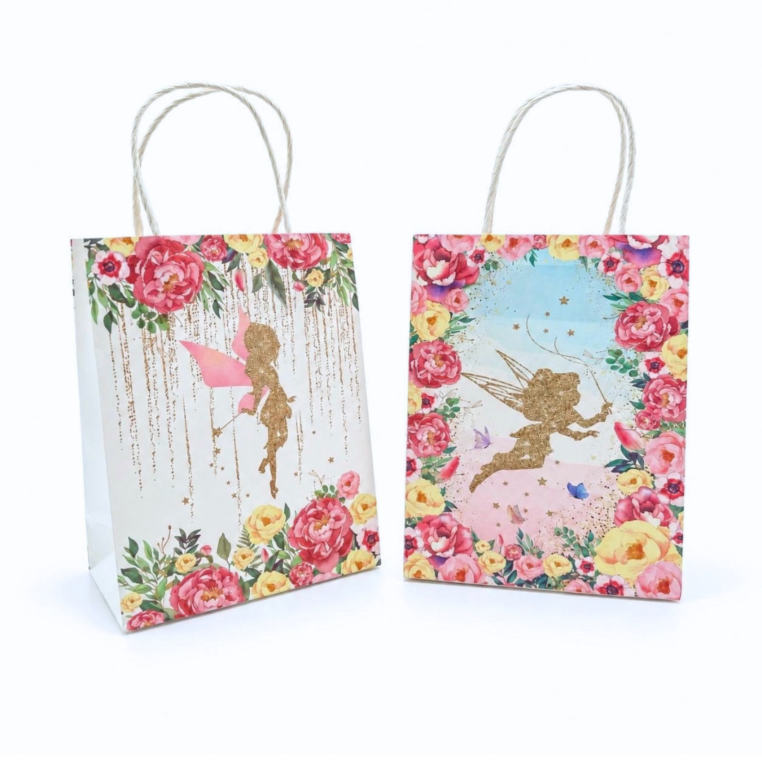 Two small gift bags with white twisted paper handles, decorated with colorful floral borders and gold fairy illustrations, shown on a plain white background.