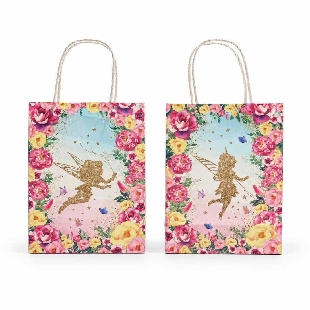 Two matching gift bags with rope handles, decorated with a colorful floral border and a gold fairy illustration on a light pastel background, shown on a white studio background.