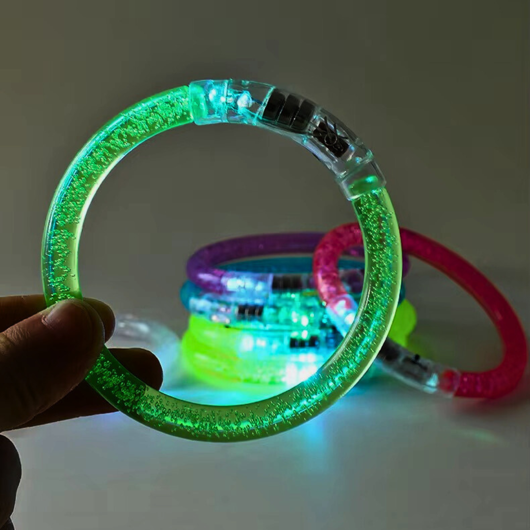 Green LED bracelet being held with other colorful LED bracelets in the background.