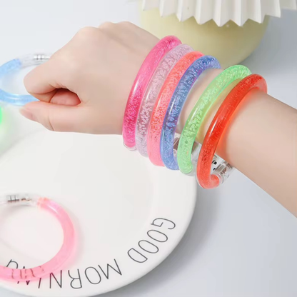 Colorful bracelets on a child's wrist with a 'Good Morning' plate in the background