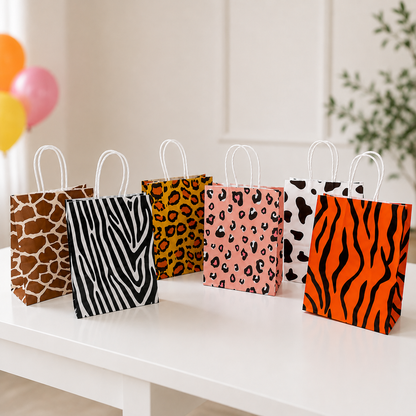 Animal print party favor bags displayed on a white table with colorful balloons in a bright birthday party setting.