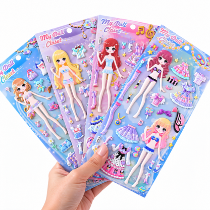 Four colorful children's doll clothing sets in plastic packaging, fanned out and held by a hand against a plain white background. Each package contains a doll figure and small accessories like dresses, shoes, and bows.
