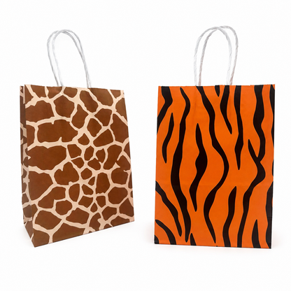 Two paper gift bags with twisted white handles on a white background. The left bag has a brown and beige giraffe print, and the right bag has an orange and black tiger stripe pattern.