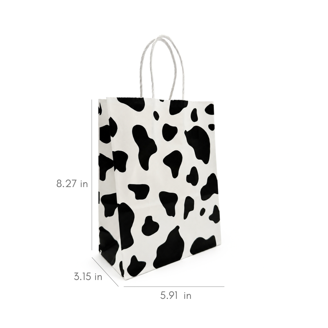 A small paper gift bag with a black and white cow print pattern and white twisted rope handles, shown with dimension lines and measurements indicating 8.27 in height, 3.