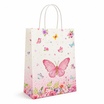 A white paper gift bag with white rope handles, decorated with a pink watercolor butterfly, pink and purple flowers, and small gold polka dots on a white background.